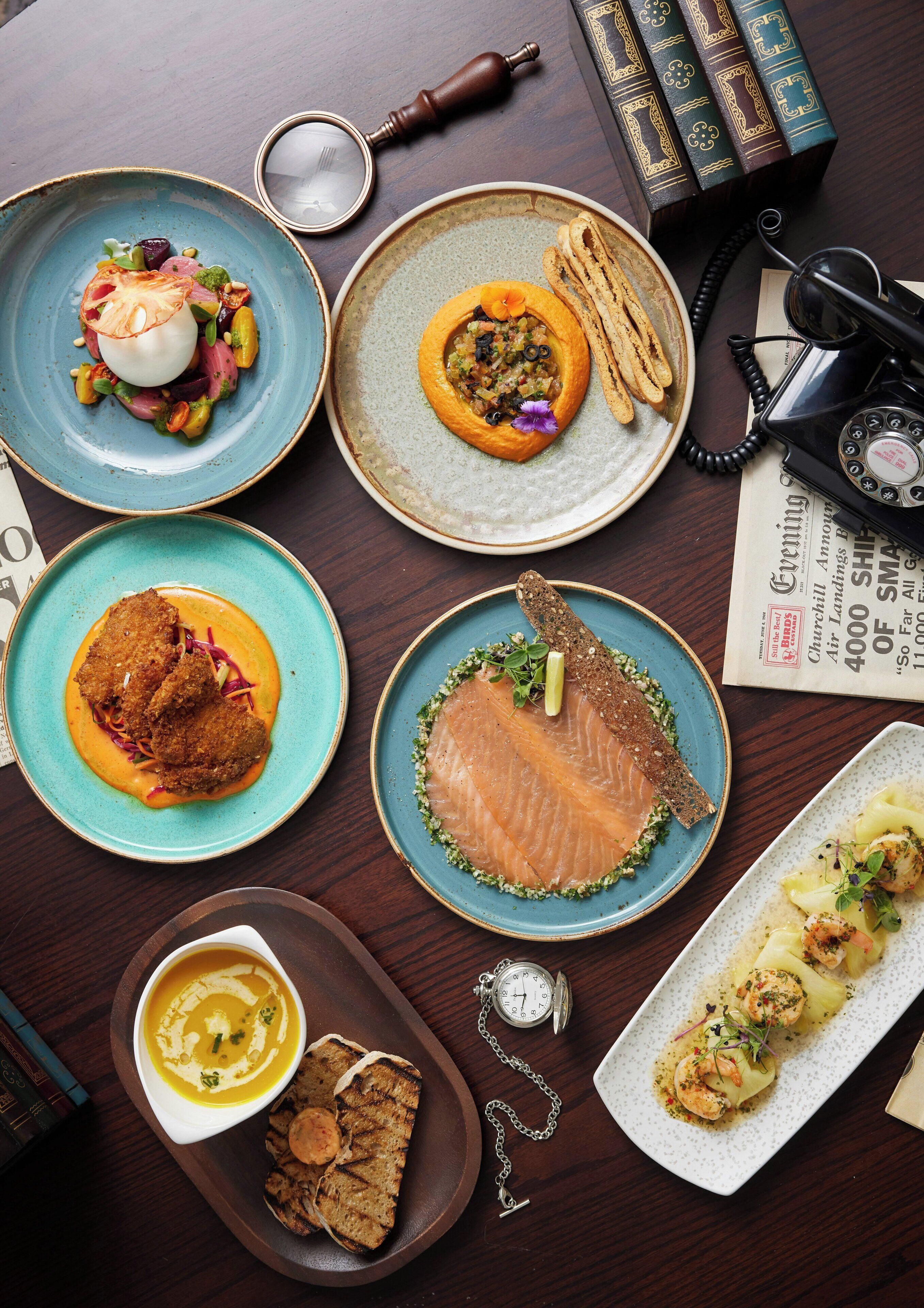 A table with various dishes, a telephone, and books.