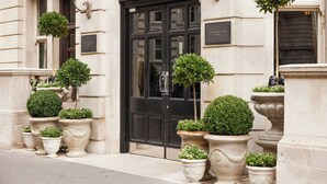 A building entrance with a black door, potted plants, and a sign that reads 'The Royal Horseguard Hotel.' - The Royal Horseguards, London (London)