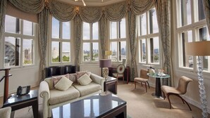 A spacious room with a large window, a sofa, a coffee table, and a dining area. - The Royal Horseguards, London (London)