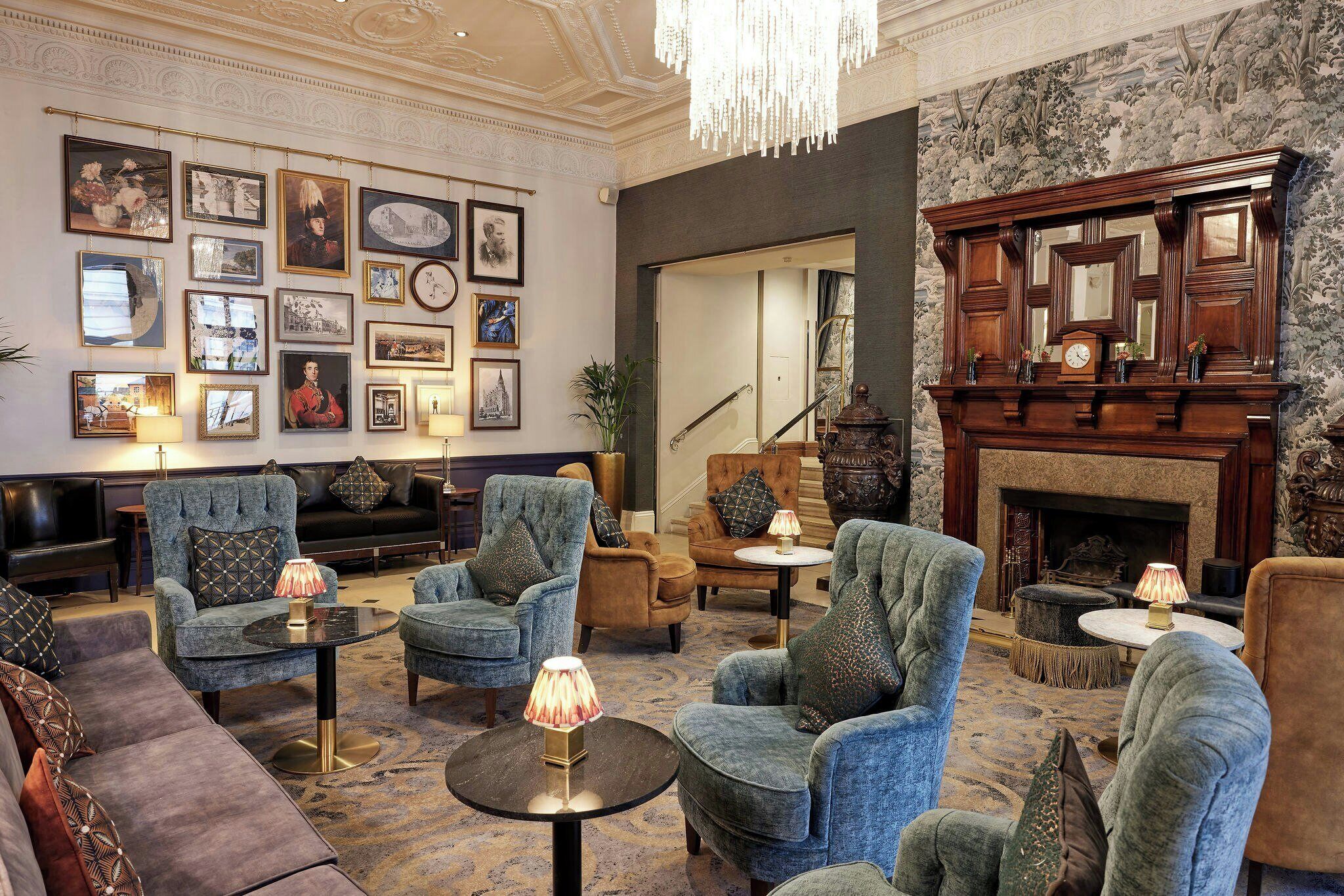 A well-appointed lounge with plush seating, a fireplace, and a wall adorned with framed pictures.