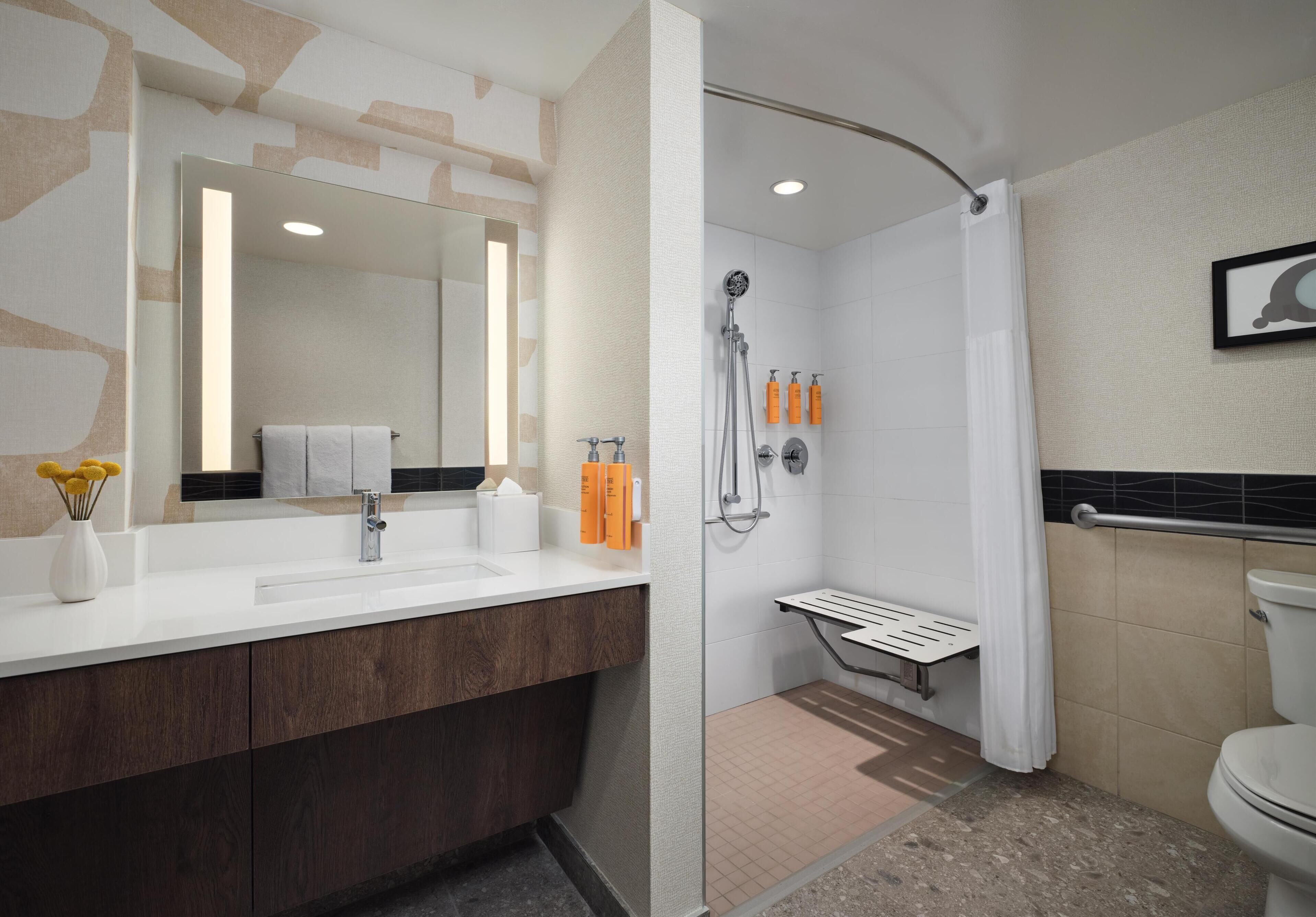 Een moderne badkamer met een douche, toilet en wastafel.