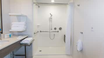 Een moderne badkamer met een inloopdouche, een wastafelmeubel met een wastafel en een handdoekrek, en een toilet.