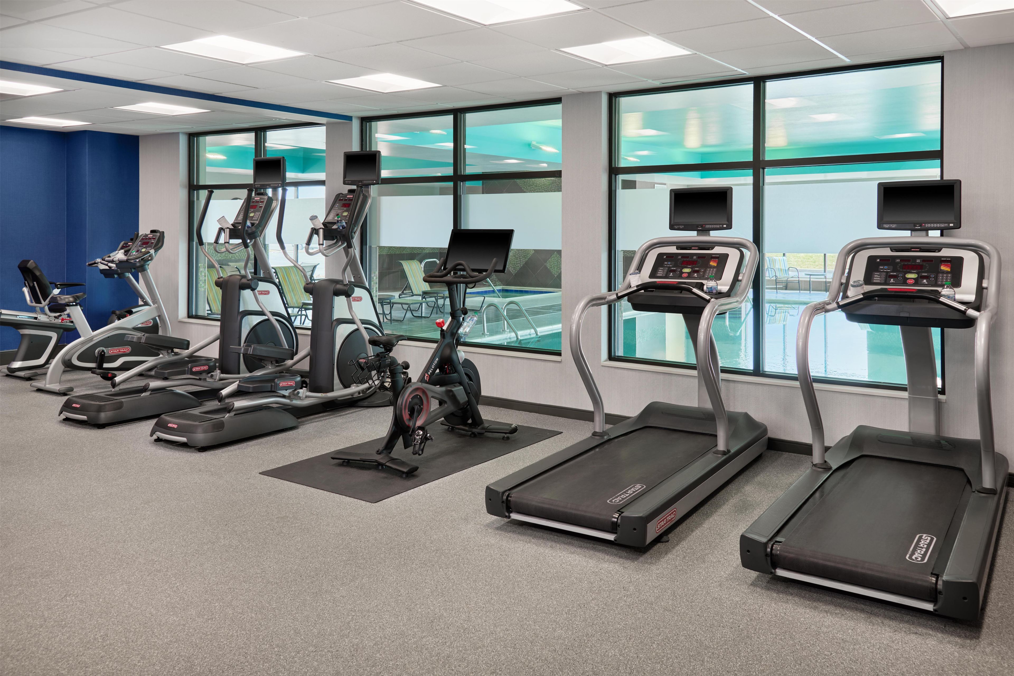 A fitness center with treadmills, elliptical machines, and stationary bikes.