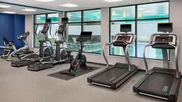 A fitness center with treadmills, elliptical machines, and stationary bikes.