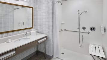 A modern bathroom with a shower, a sink, and a mirror.