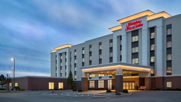 A Hampton Inn & Suites hotel with a modern facade, large windows, and a welcoming entrance. - Hampton Inn & Suites Syracuse North Airport Area (Liverpool)