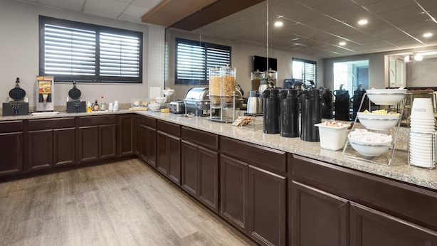 A kitchen area with a long counter, various appliances, and food dispensers.