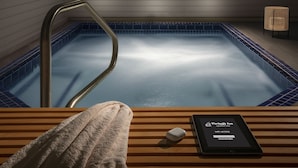 A wooden bench with a towel and a tablet displaying 'Parkway Inn of Jackson Hole' WiFi access.