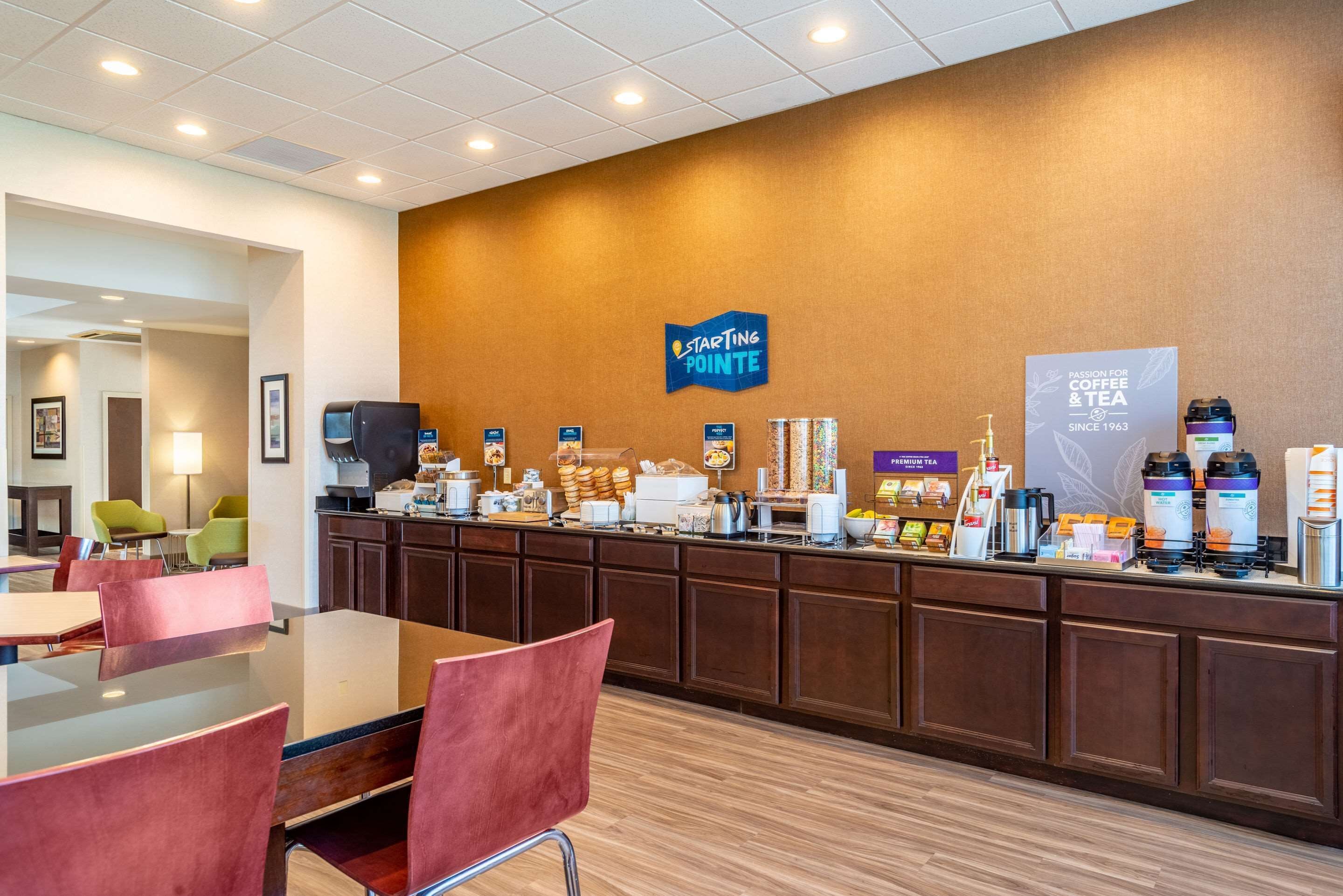 En hotellreception med en kaffestation, en sittgrupp och en skylt med texten ”Starting Pointe”.