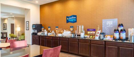 En hotellreception med en kaffestation, en sittgrupp och en skylt med texten ”Starting Pointe”.