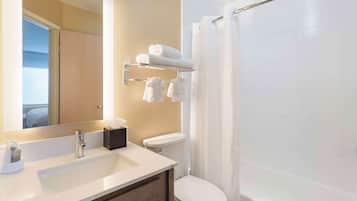 A modern bathroom with a sink, mirror, towel rack, and shower.