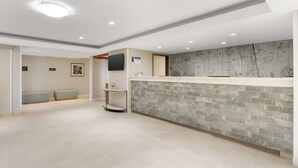 A reception area with a stone counter, a map on the wall, and a seating area with a sofa and armchairs.