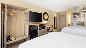 Une chambre d’hôtel avec deux lits, une télévision, un bureau avec un ordinateur, un four à micro-ondes et un mini-bar.