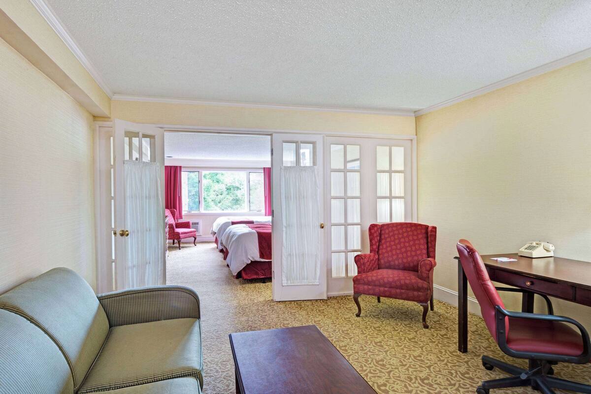 Een hotelkamer met een bed, een bureau, een stoel en een bank.
