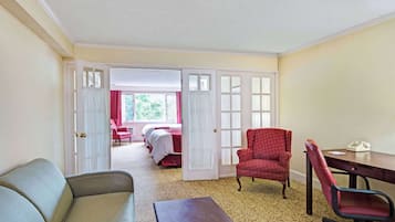 Una habitación de hotel con cama, escritorio, sillón y sofá.