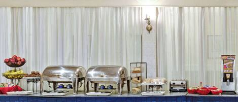 A buffet setup with various food items and appliances.