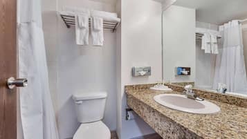 Een moderne badkamer met toilet, wastafel en douche.