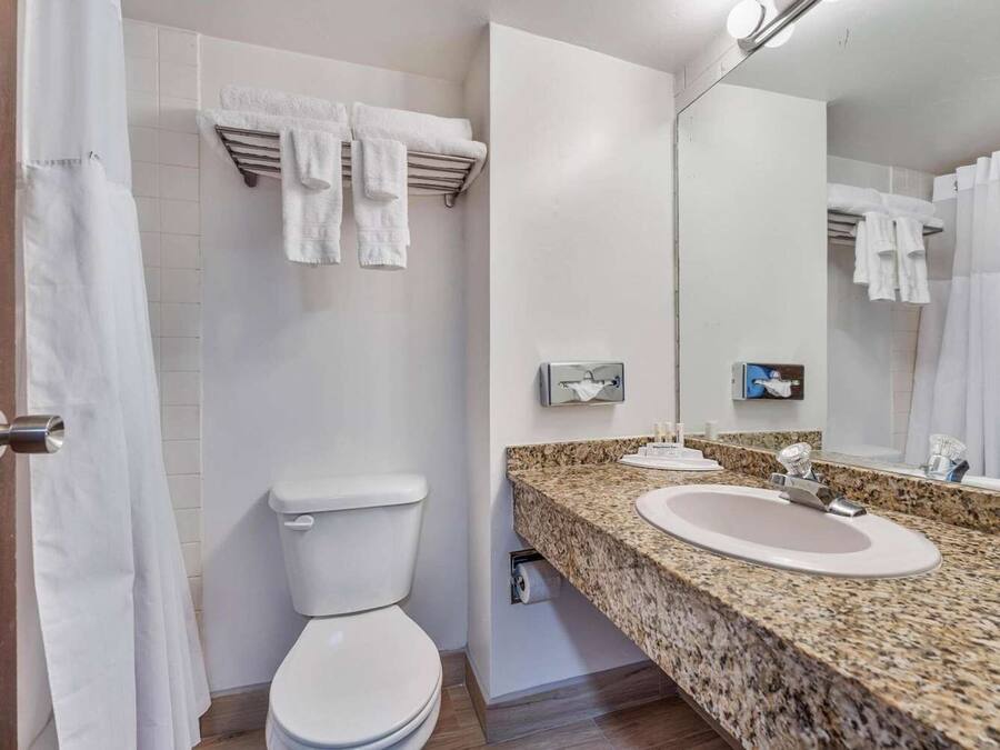 Een moderne badkamer met toilet, wastafel en douche.