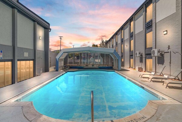 Una piscina al aire libre, sillones reclinables de piscina