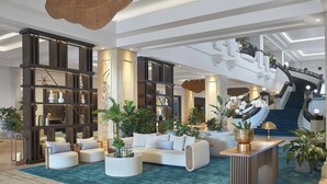 A spacious lobby with a curved staircase, a sectional sofa, and multiple potted plants. - JW Marriott Gold Coast Resort & Spa (Surfers Paradise)
