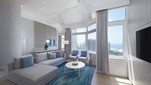 A modern living room with a grey sofa, a round coffee table, and a view of the city through large windows. - JW Marriott Gold Coast Resort & Spa (Surfers Paradise)