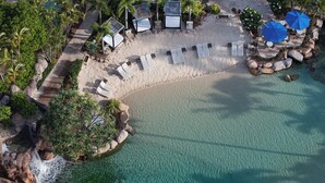 An aerial view of a beach resort with sun loungers, umbrellas, and a small waterfall. - JW Marriott Gold Coast Resort & Spa (Surfers Paradise)