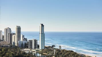 A coastal cityscape with high-rise buildings, a bridge, and a beach.