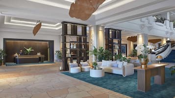 A spacious lobby with a reception desk, seating area, and staircase.