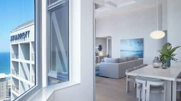 Et moderne hotelværelse med et stort vindue, et spiseområde og en opholdsstue.