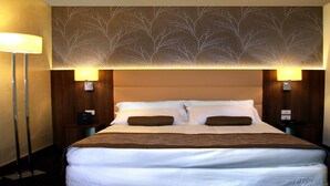 A hotel room with a large bed, two bedside tables, a wall-mounted lamp, and a decorative tree pattern on the ceiling. - LH Hotel Sirio Venice (Mestre)