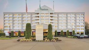A Radisson hotel with a symmetrical facade, multiple windows, and a central entrance. - Radisson Hotel Seattle Airport (SeaTac)