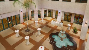 A spacious lobby with a central fountain, multiple seating areas, and large windows offering views of the interior. - Hilton Phoenix Airport (Phoenix)