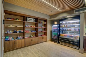 A clean, well-organized room with wooden shelving stocked with various items, a large beverage refrigerator, and a ceiling with a slatted design. - Hilton Phoenix Airport (Phoenix)