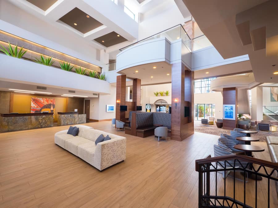 A spacious lobby with a reception desk, seating area, and a staircase.