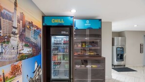 A hotel room with a minibar, a refrigerator, and a wall mural. - Clarion Pointe Indianapolis Northeast (Indianapolis)