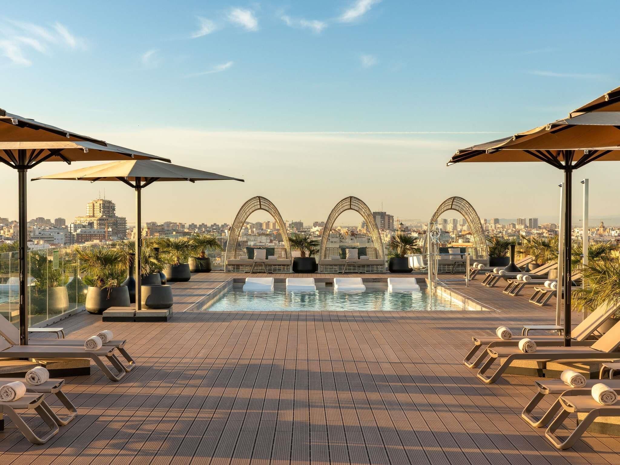 Una piscina al aire libre, sillones reclinables de piscina