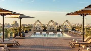 Una piscina al aire libre, sillones reclinables de piscina