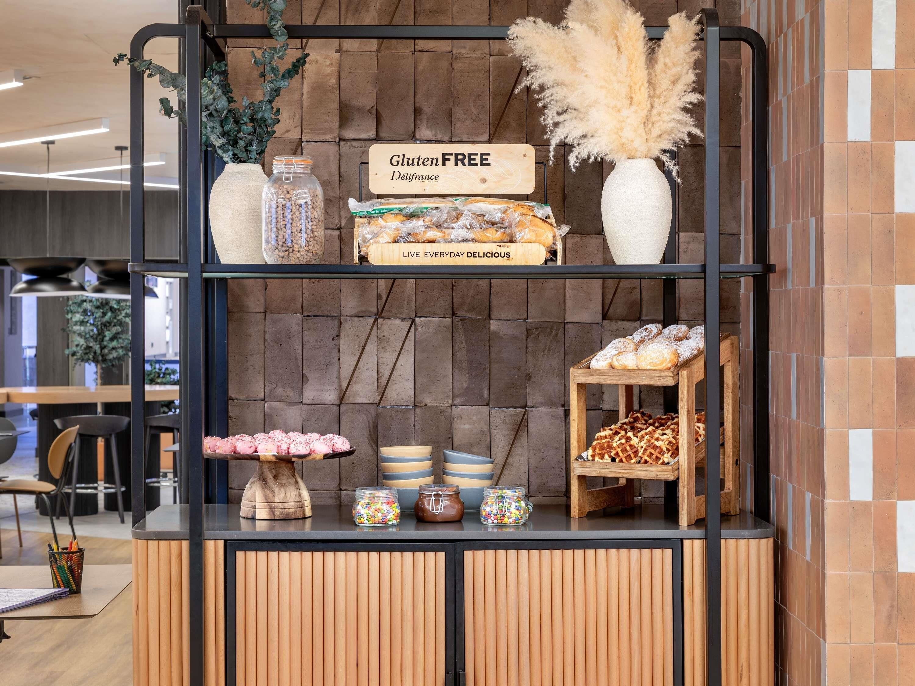 A gluten-free bakery display with various baked goods and a sign indicating gluten-free options.
