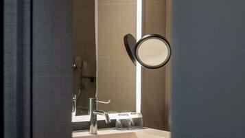 Un bagno con specchio, lavandino e porta asciugamani.