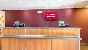A reception desk with a digital display indicating free Wi-Fi availability. - Red Roof Inn Jacksonville - Orange Park (Jacksonville)