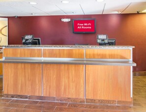 A reception desk with a digital display indicating free Wi-Fi availability. - Red Roof Inn Jacksonville - Orange Park (Jacksonville)