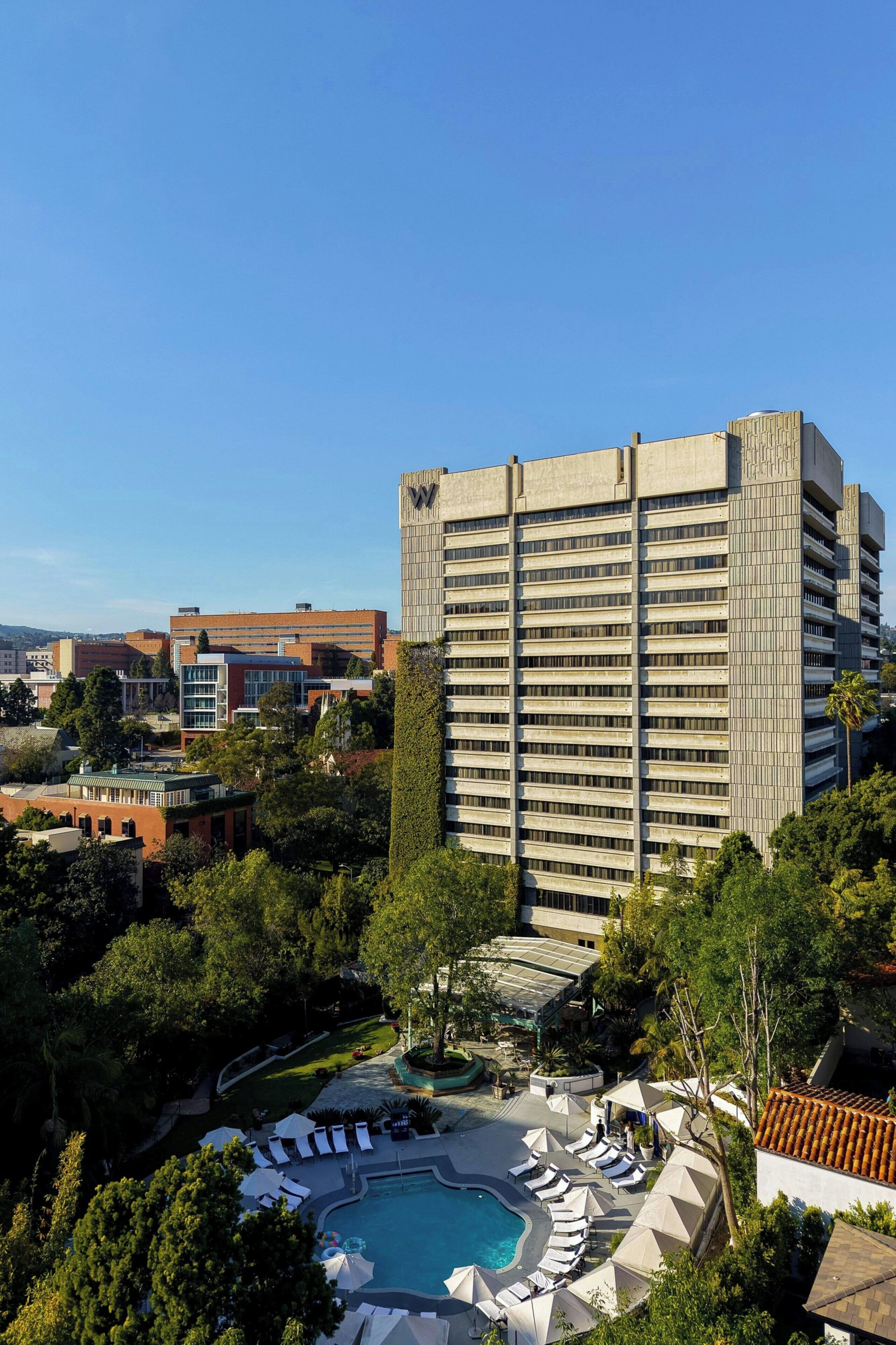 Un hotel moderno con piscina y zona de descanso.