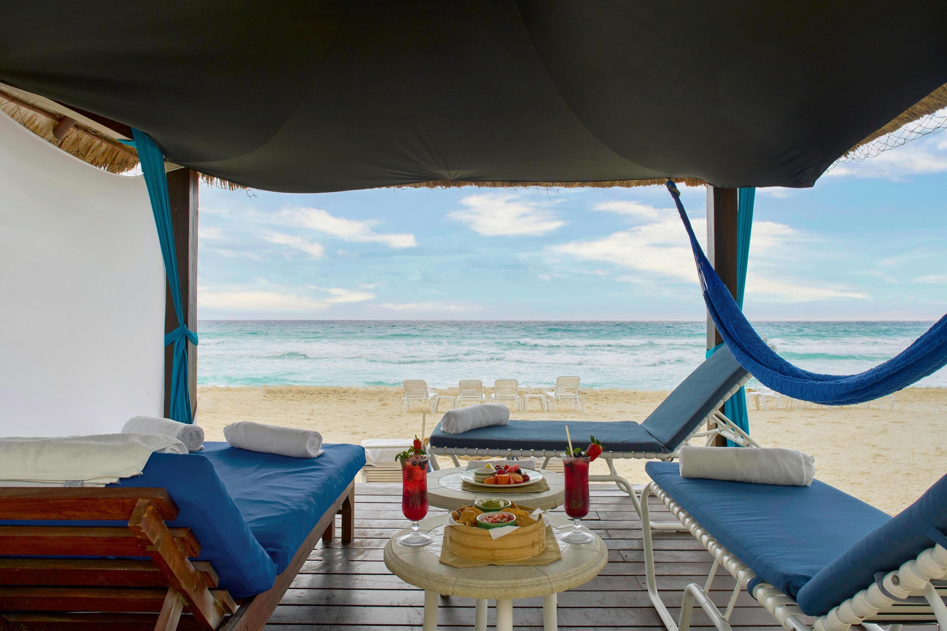 On the beach, white sand, beach cabanas, sun loungers