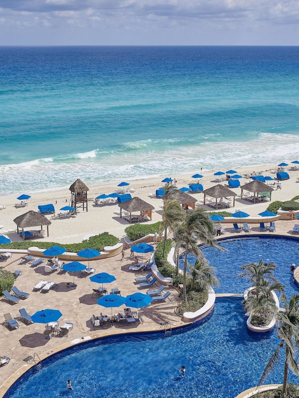 On the beach, white sand, beach cabanas, sun loungers