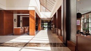 A spacious lobby with a high ceiling, a reception desk, and a view of the entrance. - The Westin Princeton at Forrestal Village (Princeton)