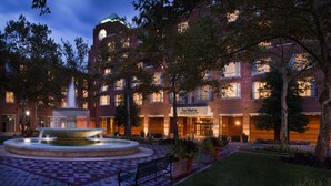 A brick building with a fountain and a bench in front. - The Westin Princeton at Forrestal Village (Princeton)