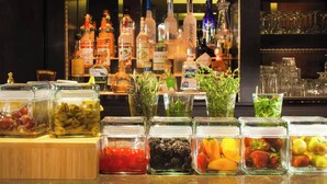 A bar area with various liquor bottles and a selection of fruits and vegetables in front of it. - The Westin Princeton at Forrestal Village (Princeton)