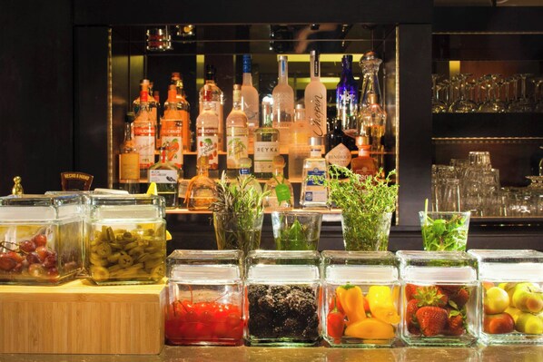 A bar area with various liquor bottles and a selection of fruits and vegetables in front of it. - The Westin Princeton at Forrestal Village (Princeton)