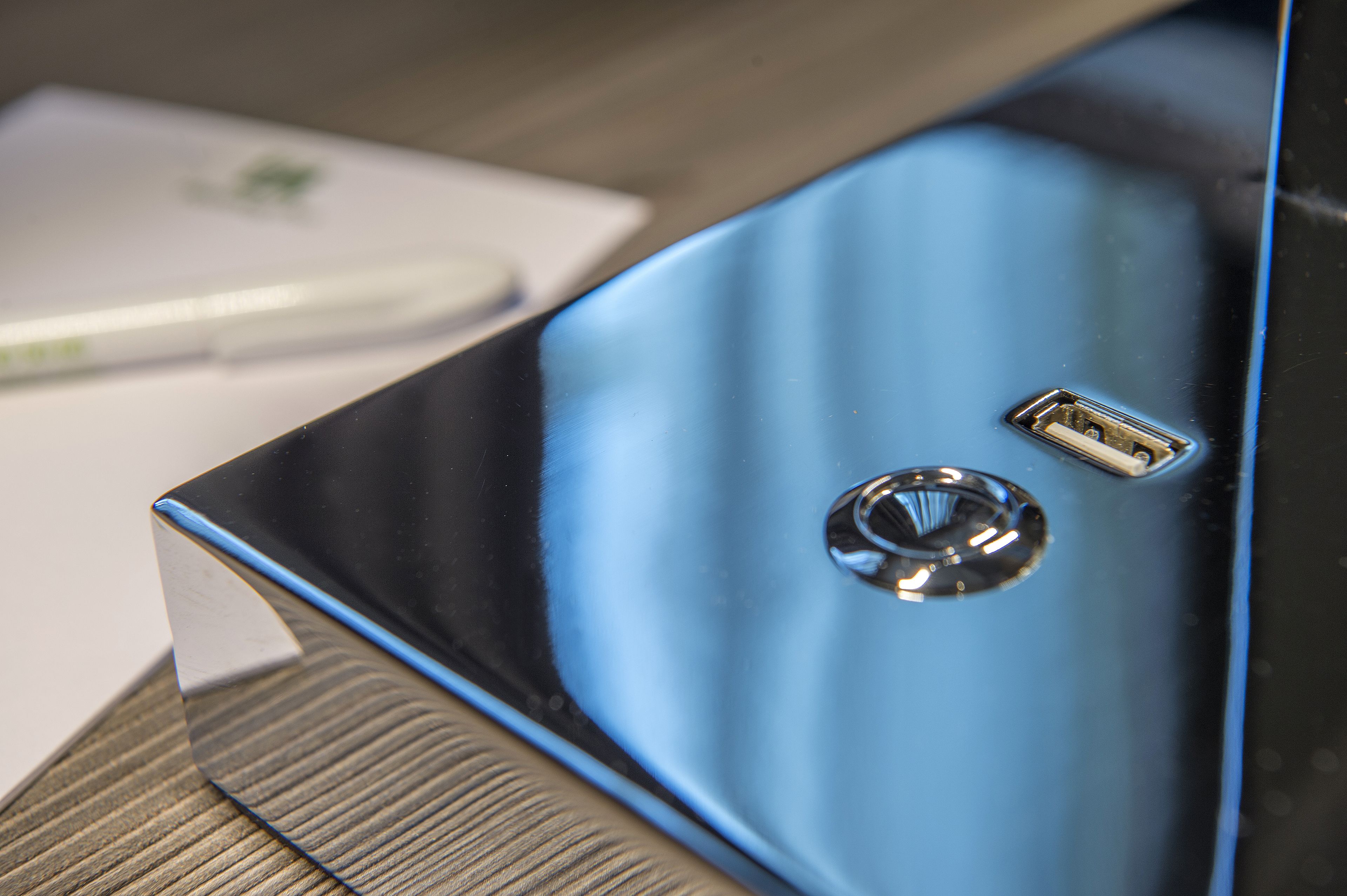 A close-up of a metallic object with a USB port and a circular indentation.