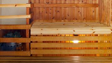 A wooden sauna with benches and a tiled floor.